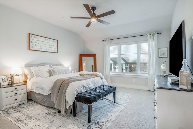 bedroom with vaulted ceiling, light colored carpet, and ceiling fan