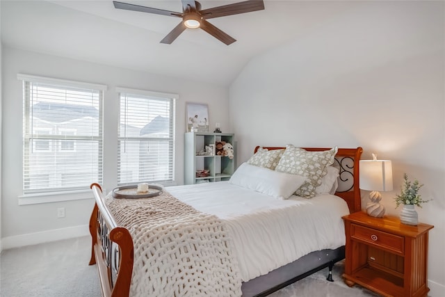 carpeted bedroom featuring multiple windows, vaulted ceiling, and ceiling fan