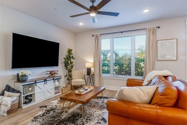 living room with ceiling fan, light wood-type flooring, and a wealth of natural light