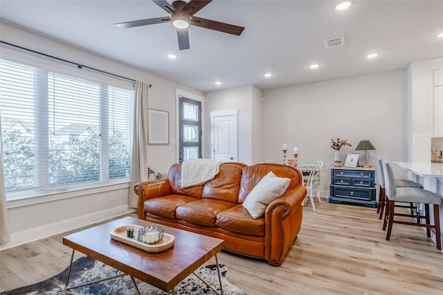 living room featuring ceiling fan, a wealth of natural light, and light hardwood / wood-style floors