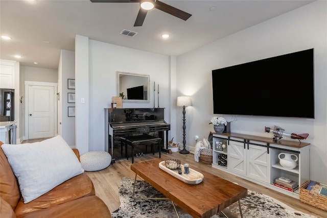 living room featuring light hardwood / wood-style floors and ceiling fan