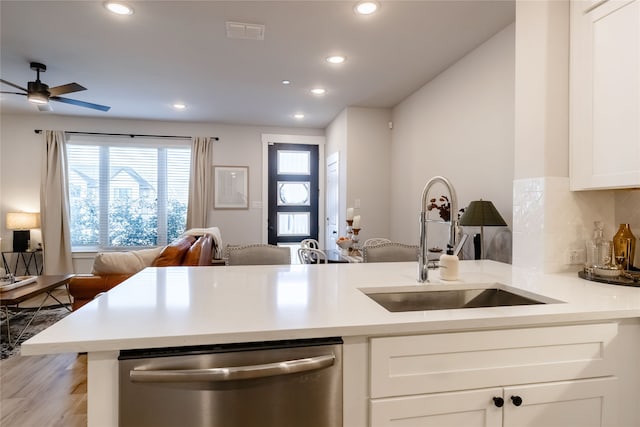 kitchen featuring tasteful backsplash, white cabinetry, dishwasher, sink, and kitchen peninsula