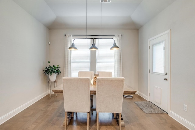 dining space with lofted ceiling and hardwood / wood-style floors