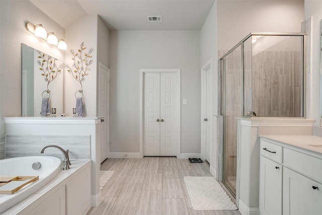 bathroom featuring vanity and shower with separate bathtub