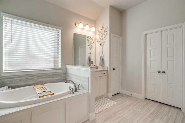 bathroom featuring vanity and a washtub