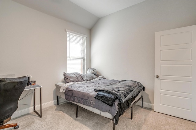 bedroom featuring light colored carpet and vaulted ceiling