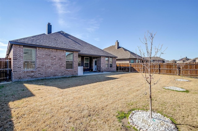 rear view of house featuring a patio and a lawn