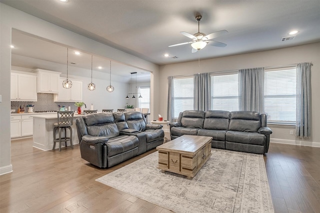 living room with ceiling fan and light hardwood / wood-style floors