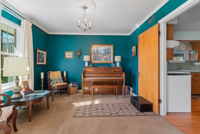 sitting room featuring sink, an inviting chandelier, light wood-type flooring, and plenty of natural light