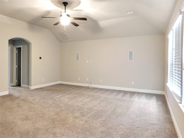 empty room with ceiling fan, light colored carpet, and vaulted ceiling