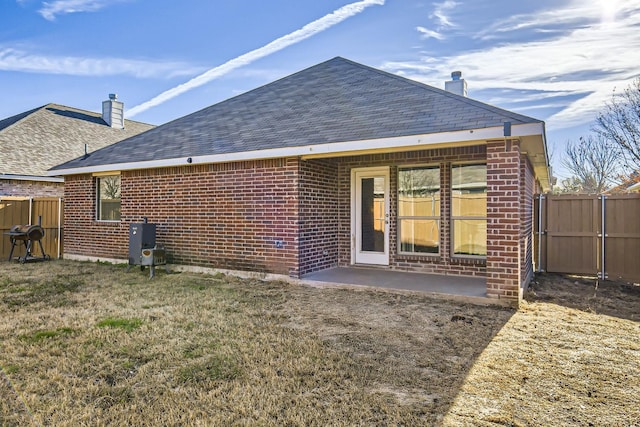 back of property featuring a yard and a patio