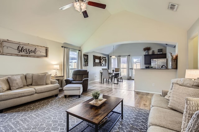 living room featuring lofted ceiling, hardwood / wood-style floors, and ceiling fan