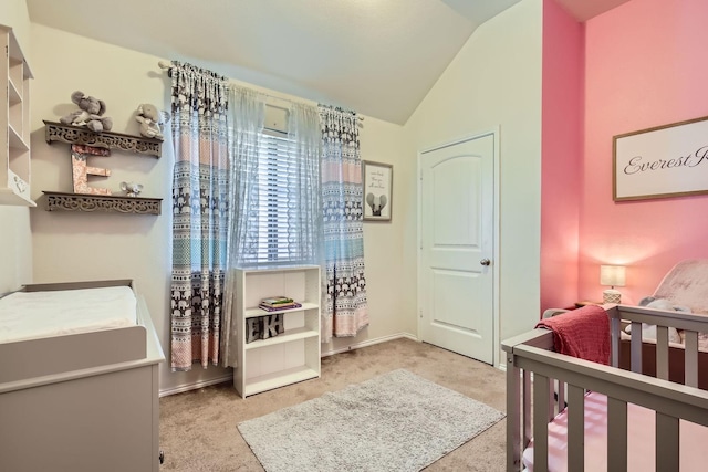 carpeted bedroom featuring a crib and vaulted ceiling