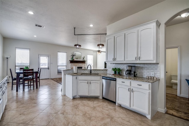 kitchen with kitchen peninsula, ceiling fan, dishwasher, and white cabinets