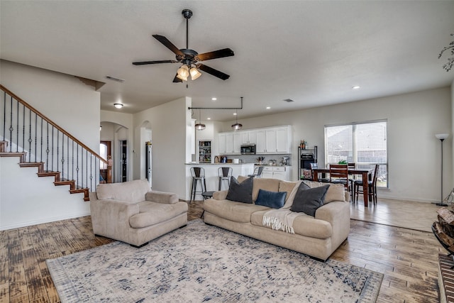 living room featuring light wood-type flooring and ceiling fan