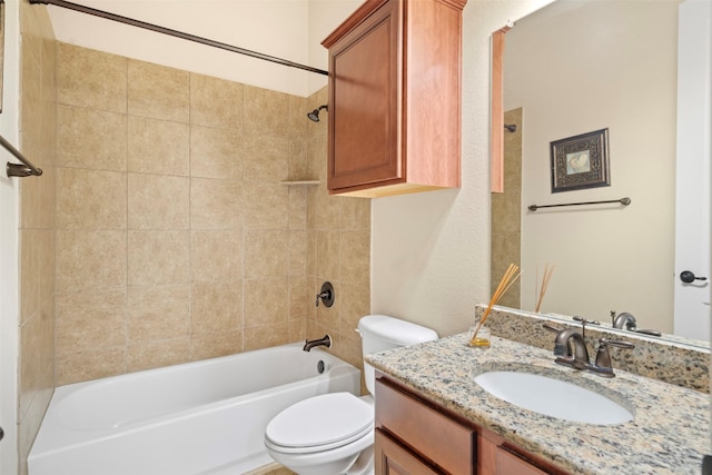 full bathroom with tiled shower / bath, vanity, and toilet