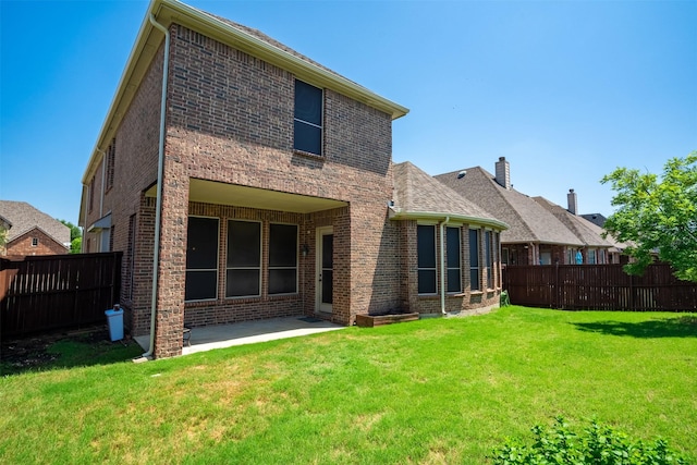 rear view of property with a patio area and a lawn