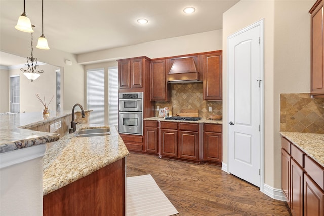 kitchen with hanging light fixtures, stainless steel appliances, custom range hood, dark hardwood / wood-style flooring, and sink