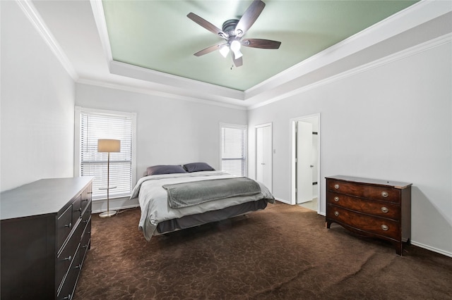 bedroom with ceiling fan, multiple windows, ornamental molding, and a raised ceiling