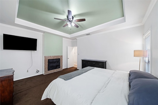 bedroom with ornamental molding, a raised ceiling, and ceiling fan