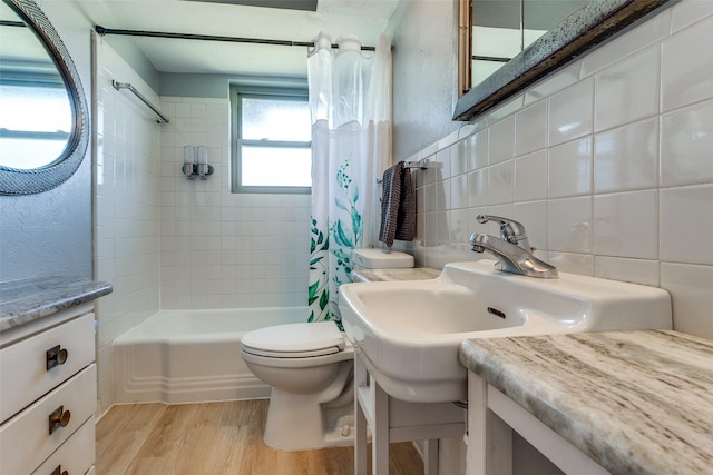 full bathroom with shower / bathtub combination with curtain, hardwood / wood-style flooring, tile walls, decorative backsplash, and toilet