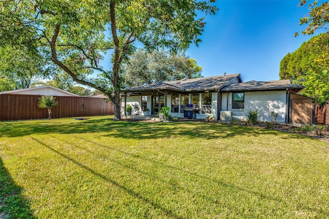 rear view of property with a yard, cooling unit, and a patio area