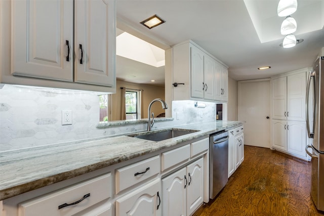 kitchen featuring sink, light stone counters, dark hardwood / wood-style floors, stainless steel appliances, and white cabinets