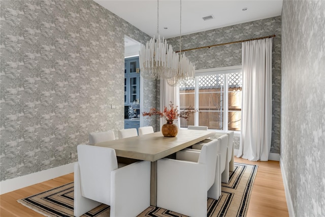 dining room featuring light wood-type flooring and a notable chandelier