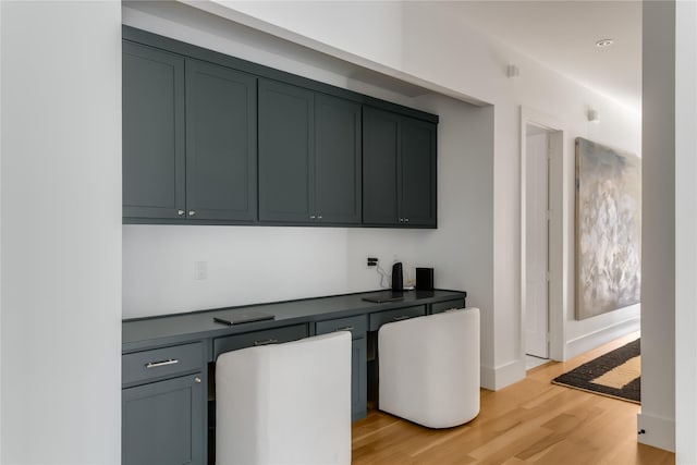 interior space featuring built in desk, gray cabinetry, and light hardwood / wood-style floors