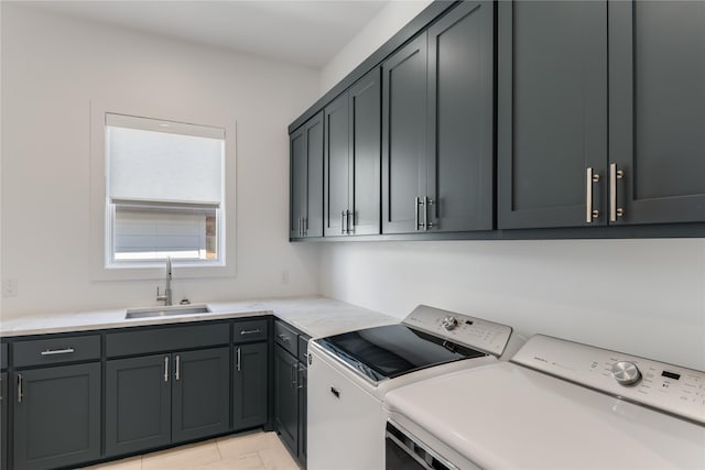 clothes washing area featuring washer and dryer, cabinets, and sink