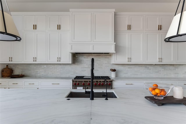 kitchen featuring white cabinets, custom exhaust hood, backsplash, and sink