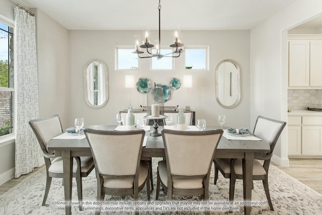 dining room with a wealth of natural light, a notable chandelier, and light hardwood / wood-style flooring