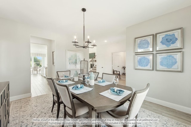 dining space with light wood-type flooring and a notable chandelier