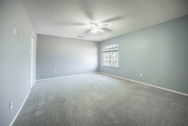 empty room with carpet floors, ceiling fan, and a textured ceiling