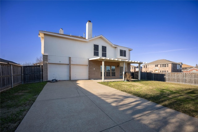 back of house with a lawn and a garage