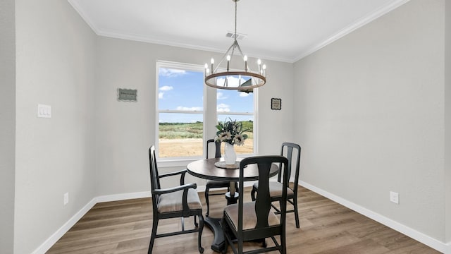 dining space with wood-type flooring, an inviting chandelier, and ornamental molding