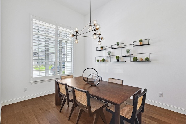 dining room with dark wood-type flooring and an inviting chandelier