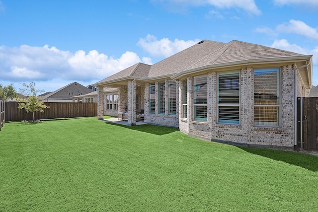 rear view of house featuring a yard and a patio area