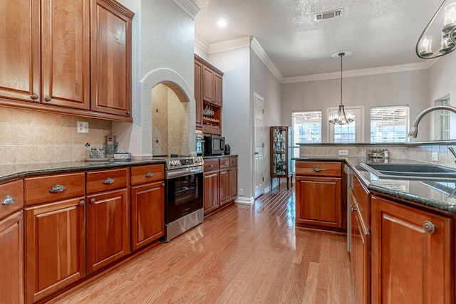 kitchen featuring brown cabinets, light wood finished floors, visible vents, an inviting chandelier, and stainless steel range with electric cooktop