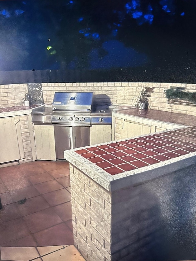 patio at twilight featuring an outdoor kitchen