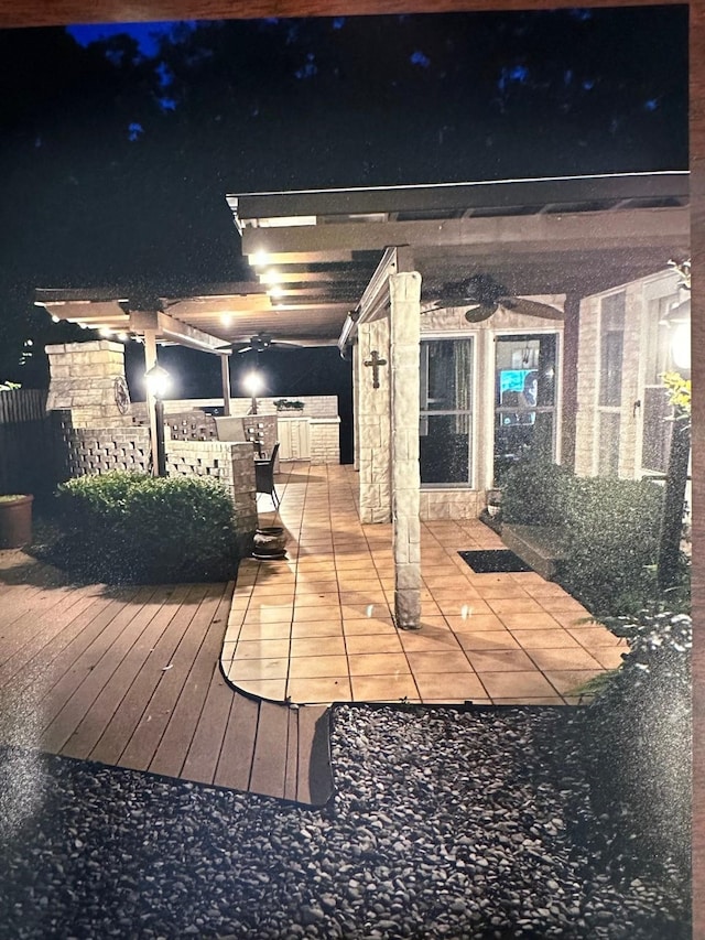 deck at night with an outdoor kitchen