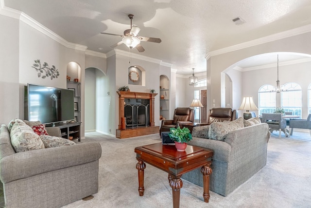 living room with light colored carpet, visible vents, arched walkways, and ceiling fan with notable chandelier