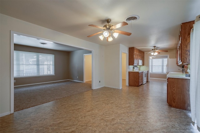 unfurnished living room with ceiling fan and sink