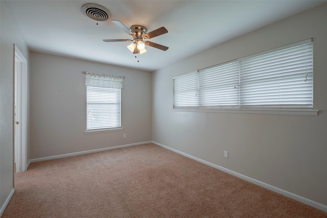 empty room featuring ceiling fan and light colored carpet