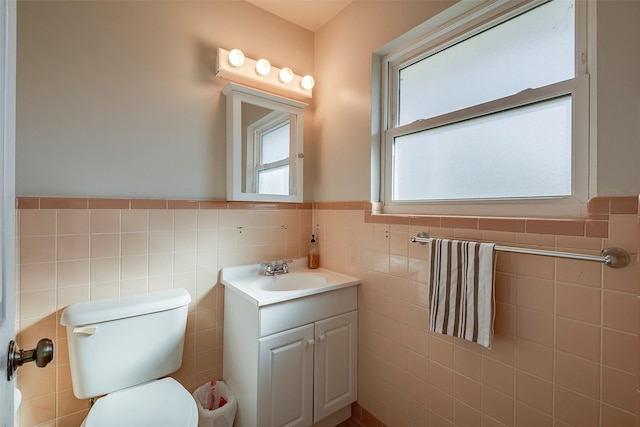 bathroom featuring vanity, tile walls, and a healthy amount of sunlight