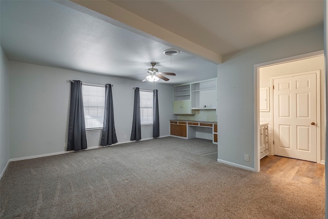 unfurnished living room featuring light carpet and ceiling fan