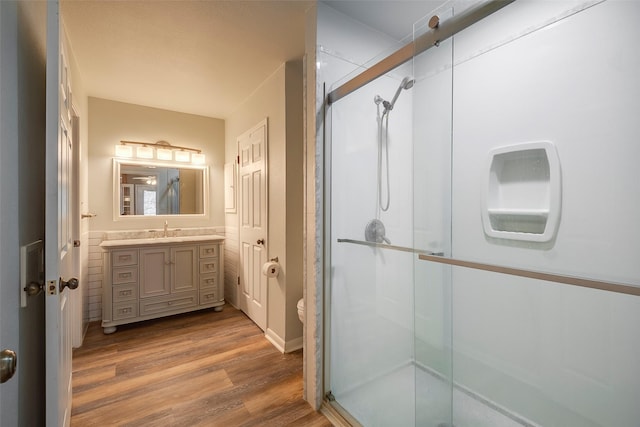 bathroom with vanity, wood-type flooring, and a shower with door