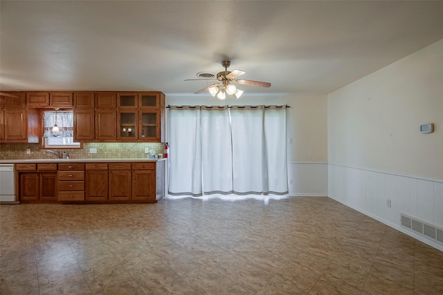 kitchen with ceiling fan, backsplash, dishwasher, and sink