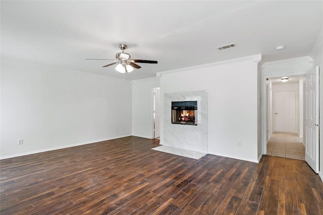 unfurnished living room with ornamental molding, dark hardwood / wood-style flooring, a fireplace, and ceiling fan