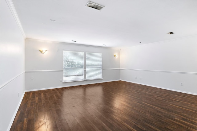 spare room with ornamental molding and dark hardwood / wood-style floors